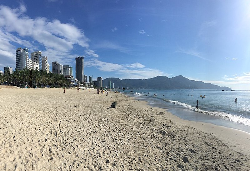 Beach with city skyline in the distance.