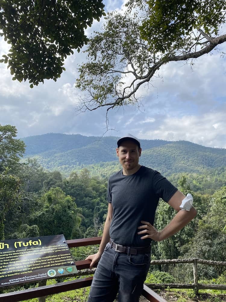 Man standing in a green landscape.