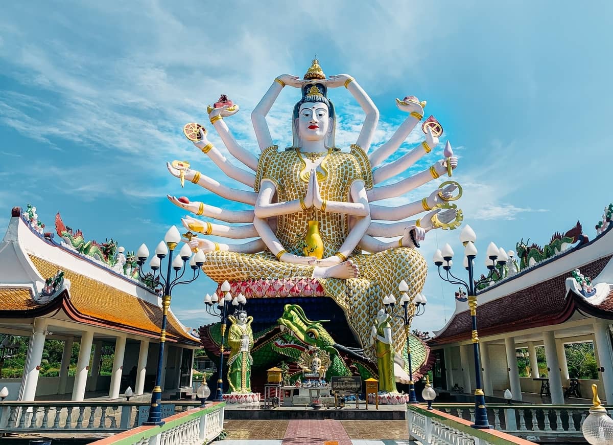 Giant Buddha statue sitting with sky background.