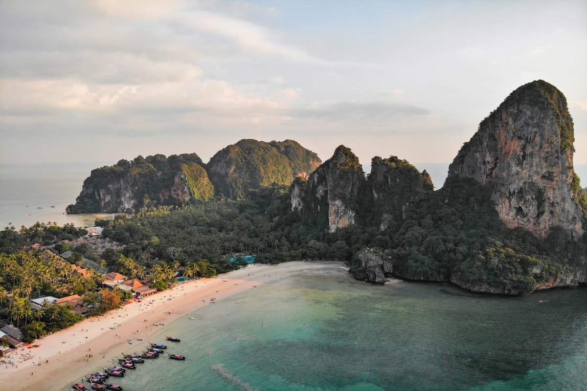 Beach with boats and limestone cliffs.