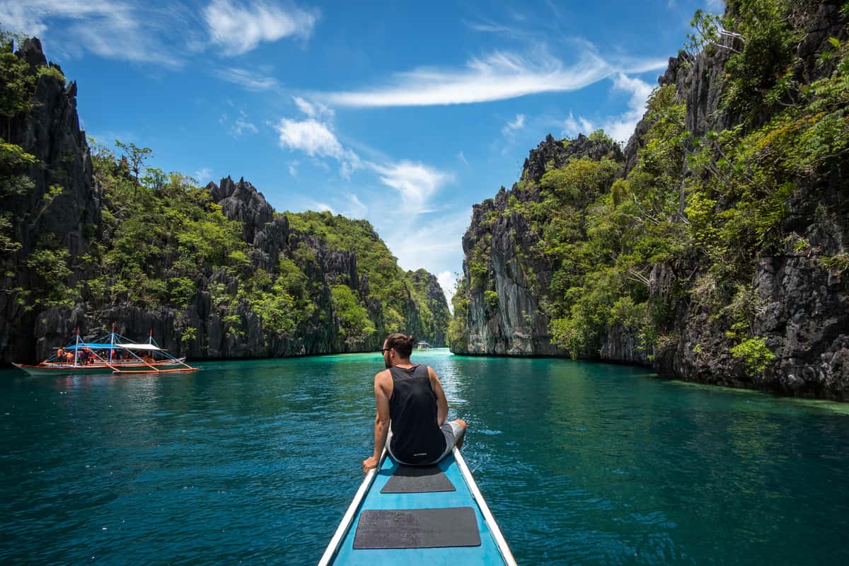 Tourist on boat in serene green waters.