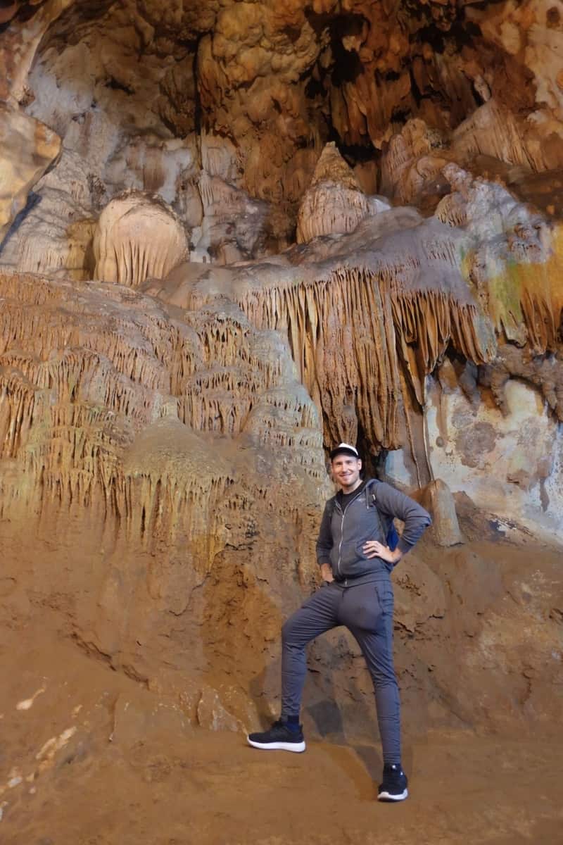 Man climbing in a rocky cave.