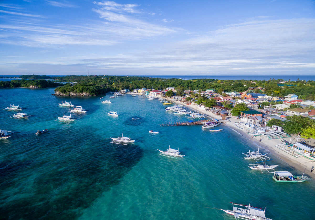 Tropical beach with boats and clear water.