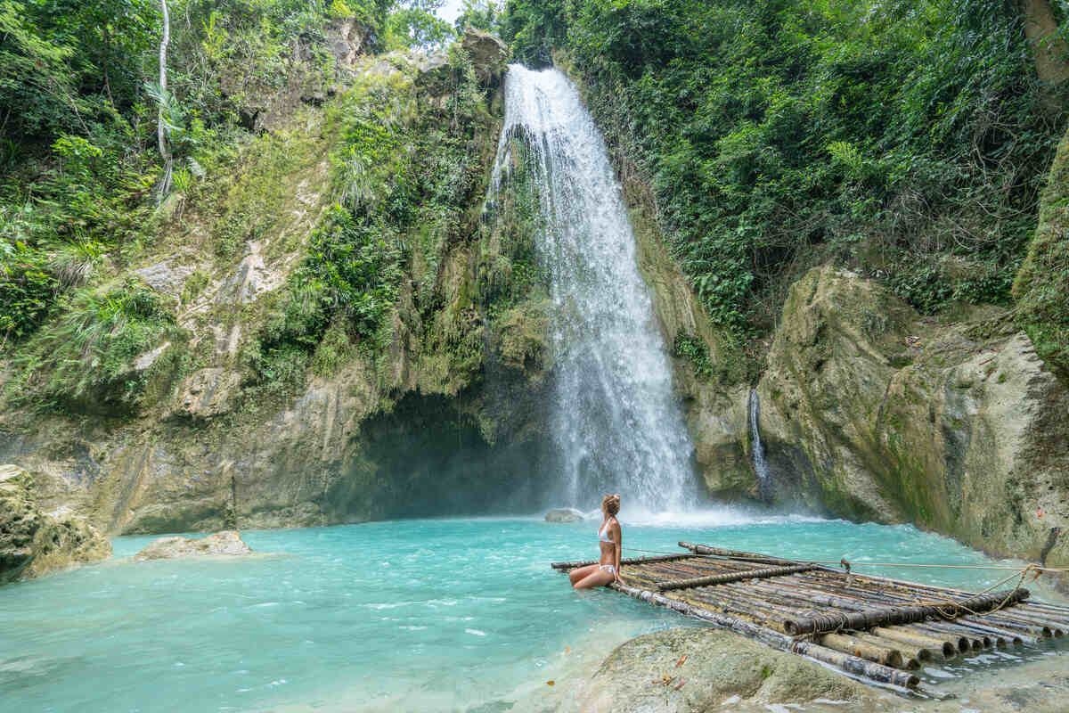 Cliffside waterfall with person posing.