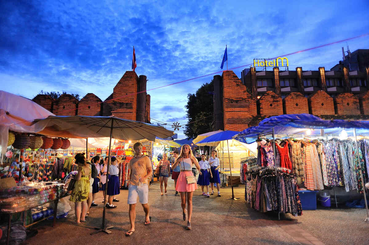 A night view of a city street with people, illuminated by warm lighting.