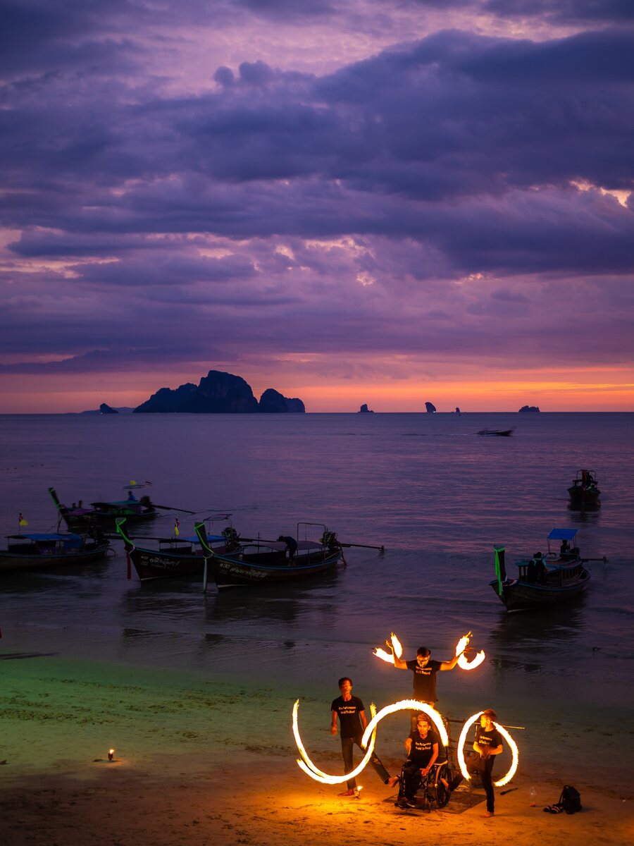 Tranquil beach sunset with boats silhouette.