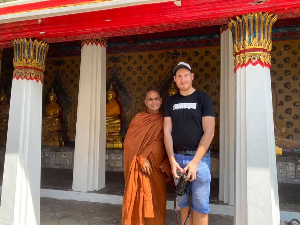 Traveler and monk smiling together.