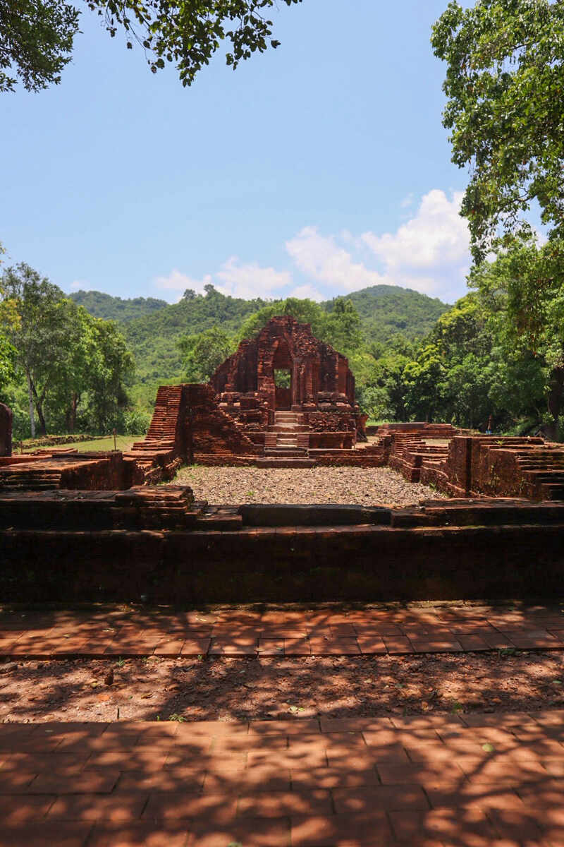 Brick temple ruins amidst greenery.