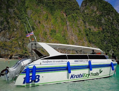 Speedboat on clear waters near a beach.