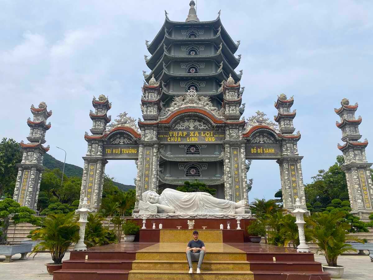 Elaborate temple gateway with statues and carvings. Reclining Buddha statue at the Da Nang Lady Buddha