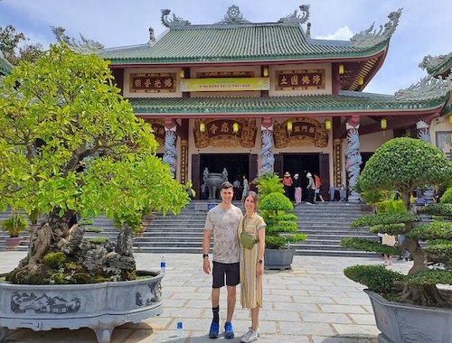 Temple entrance with traditional architecture and red pillars.