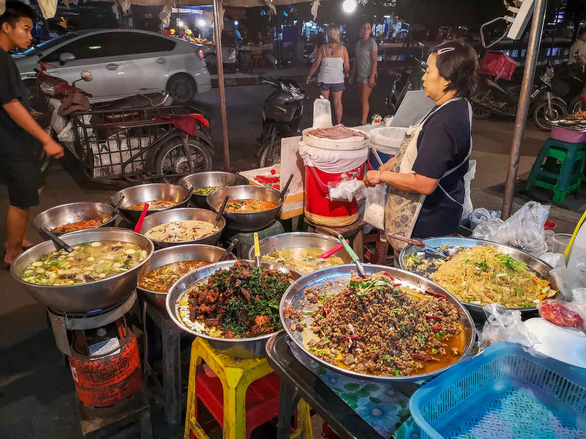 Busy evening market with bright lights and Asian food