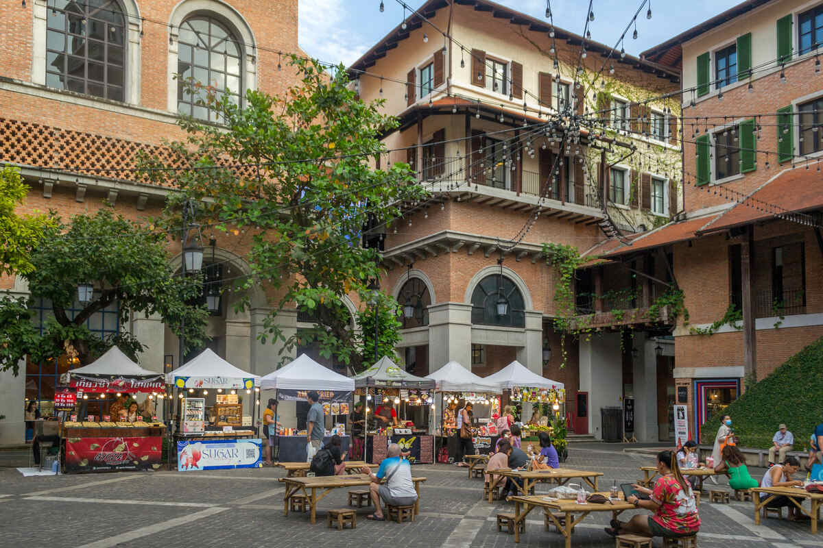 Quaint multi-storied building with balconies and a market at the base