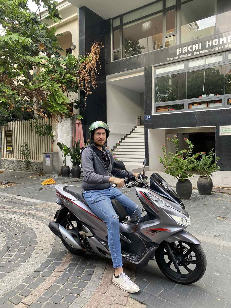 Man on a motor scooter in a narrow street. Renting-a-Motorbike-from-Hoi-An-to-Marble-Mountains