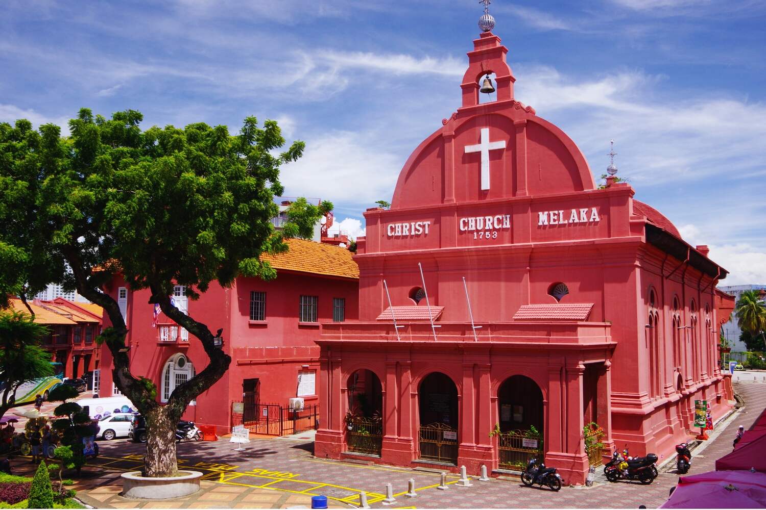 Red church in Melaka Malaysia with a beautiful tree and a square downstairs