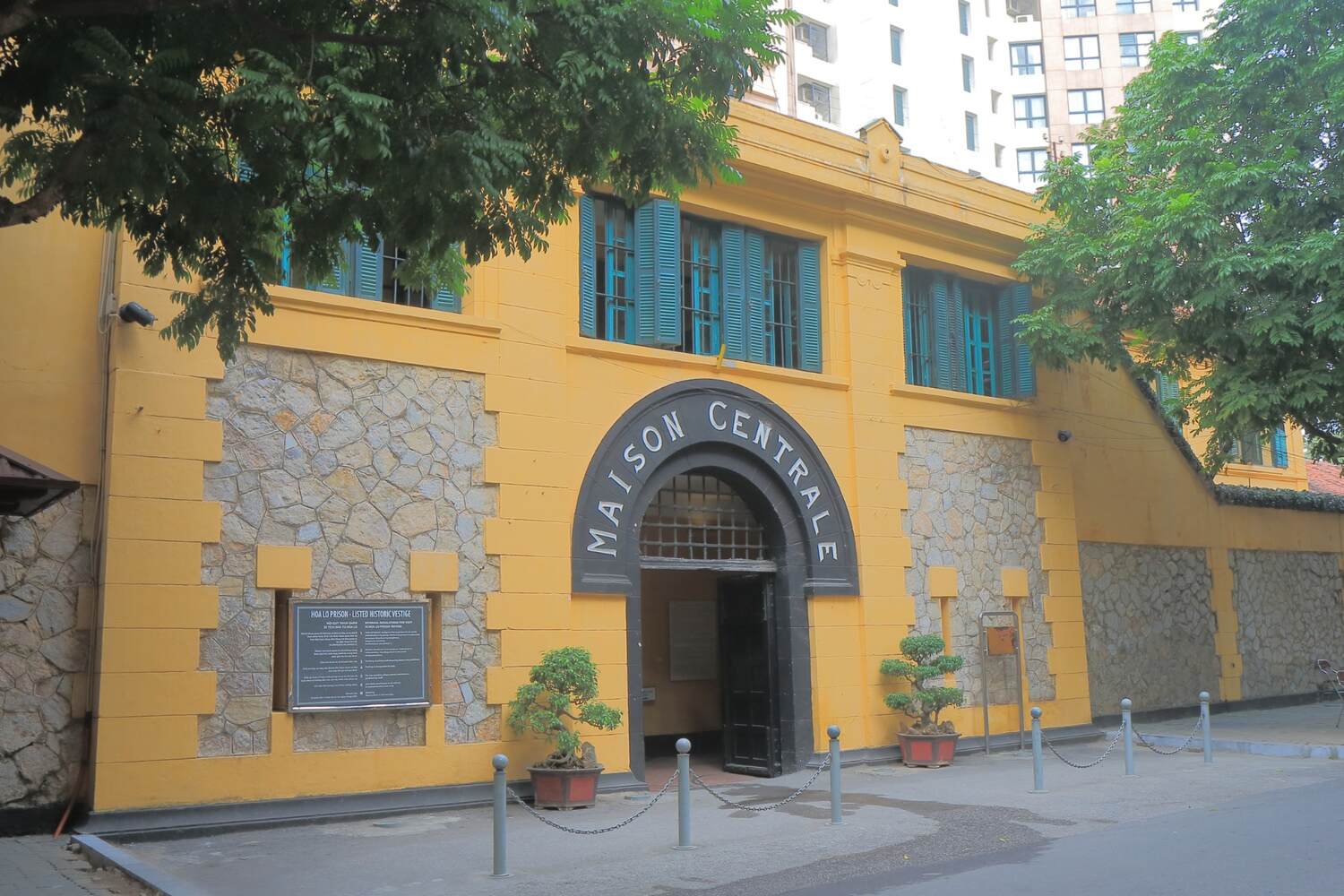 Rustic yellow building with blue shutters, representing traditional European architecture.