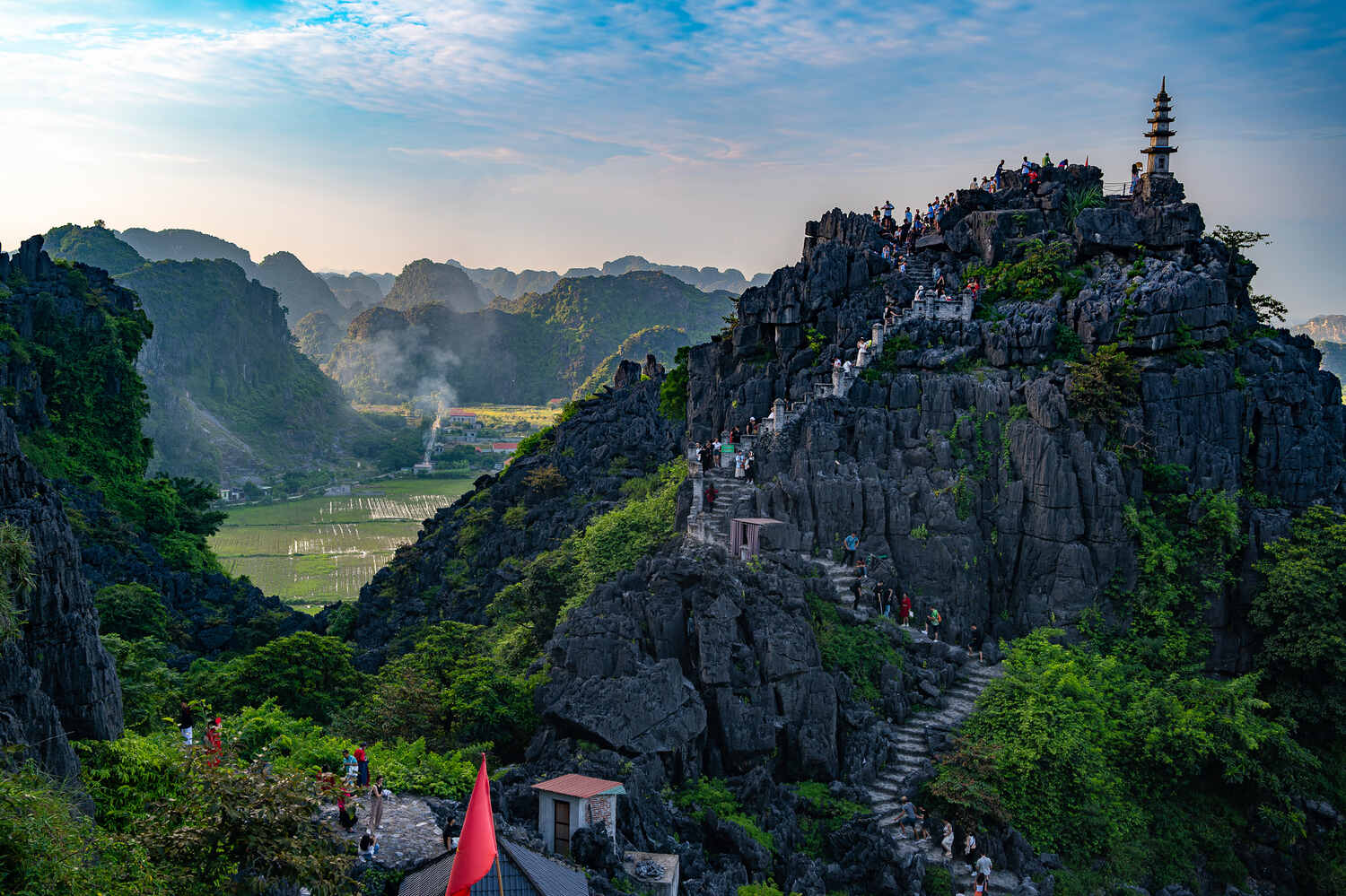 Tourists climbing steep stairs on a mountain at Trang An Scenic Landscape Complex